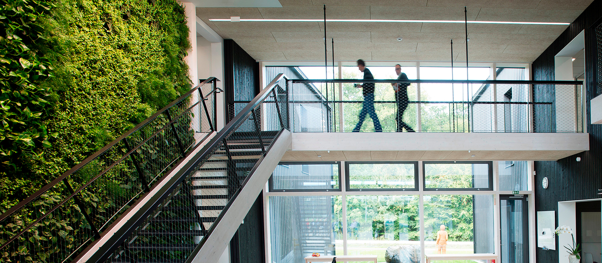 Avoin toimistotila Väla Gårdissa, jossa on viherseinä, portaikko ja parvi.