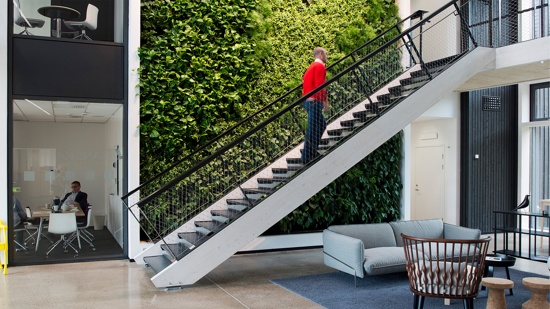 Toimiston sisätila Väla Gårdissa, jossa on viherseinä, portaikko ja oleskelualue.